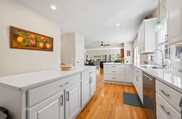 kitchen with white cabinets, a sink, dishwasher, recessed lighting, and open floor plan