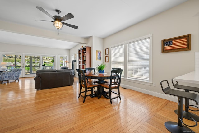 dining space featuring baseboards, light wood finished floors, and ceiling fan