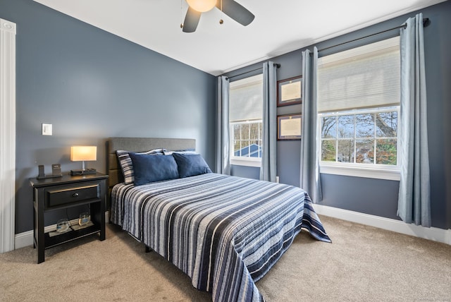 carpeted bedroom with a ceiling fan and baseboards