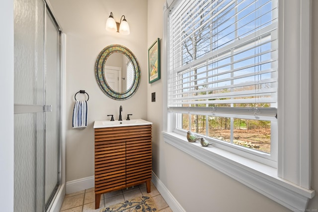 full bath with vanity, baseboards, and a stall shower