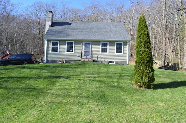 view of front of home with a chimney, a shingled roof, a front yard, and entry steps