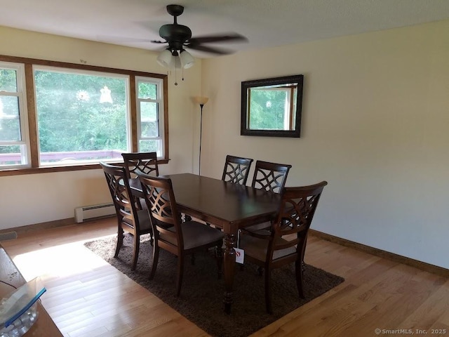 dining area featuring baseboards, ceiling fan, baseboard heating, and light wood-style flooring