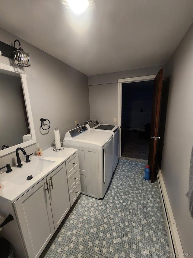 laundry room featuring a sink, a baseboard radiator, and washing machine and clothes dryer