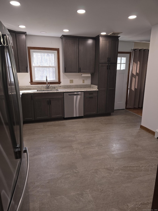 kitchen with stainless steel dishwasher, freestanding refrigerator, dark brown cabinetry, recessed lighting, and a sink