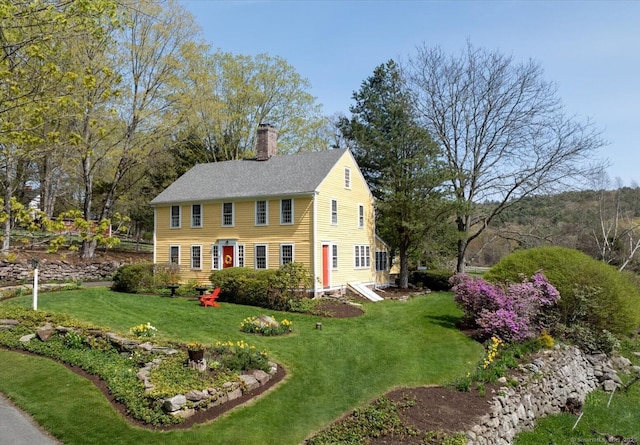 view of front of property featuring a chimney and a front lawn