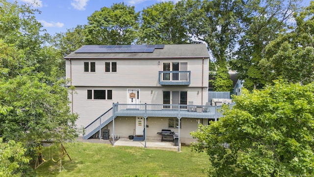 117 Mansfield Grove Rd, East Haven, CT 06512 - rear view of property featuring a balcony, roof mounted solar panels, a patio area, a yard, and stairs