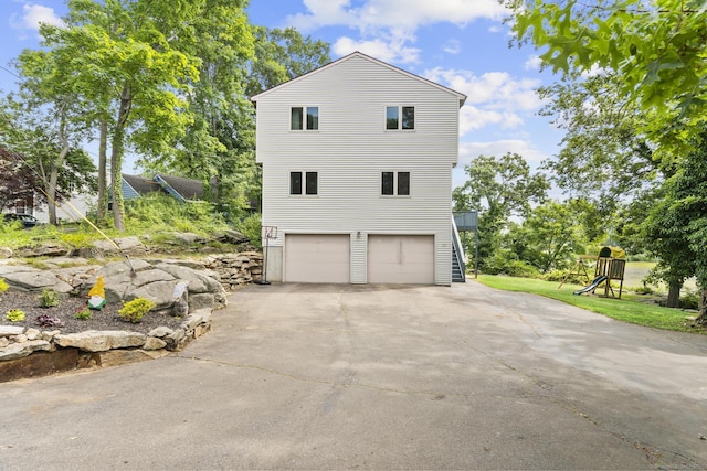 117 Mansfield Grove Rd, East Haven, CT 06512 - view of side of home featuring concrete driveway, an attached garage, and a playground