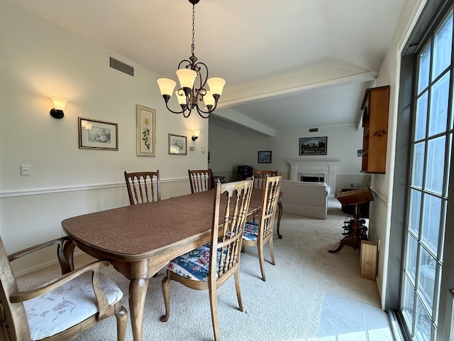 dining area with light colored carpet, a fireplace, a chandelier, lofted ceiling, and baseboards