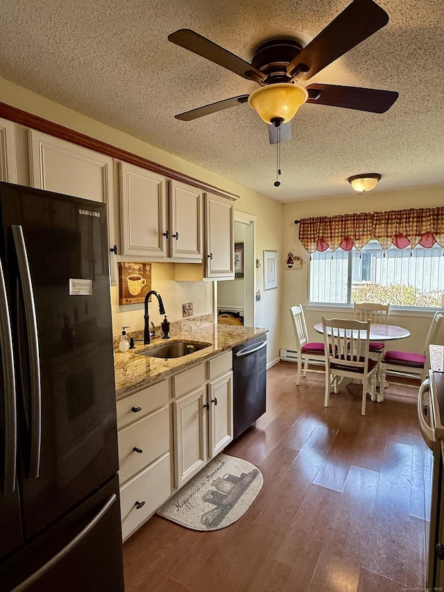 kitchen featuring freestanding refrigerator, stainless steel dishwasher, a sink, a ceiling fan, and a textured ceiling