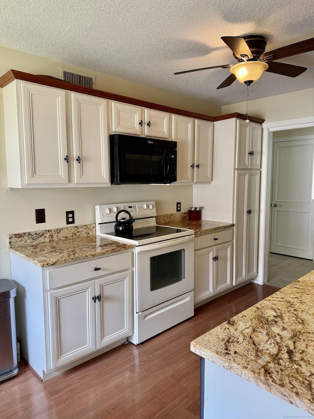 kitchen with black microwave, white electric range, wood finished floors, white cabinets, and a ceiling fan