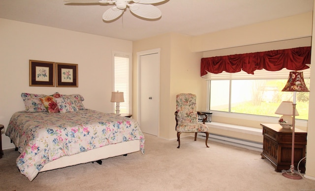 carpeted bedroom with a baseboard radiator, ceiling fan, and a closet