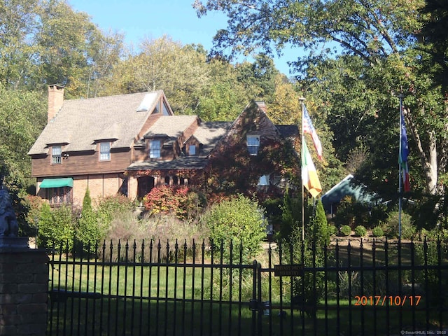 view of front facade with fence and a chimney