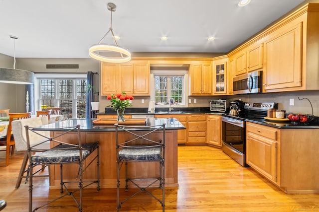 24 Scott Rd, Oxford, CT 06478 - kitchen featuring stainless steel appliances, a sink, a kitchen bar, dark countertops, and light wood-type flooring