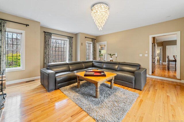 24 Scott Rd, Oxford, CT 06478 - living area with a chandelier, healthy amount of natural light, light wood-style flooring, and baseboards