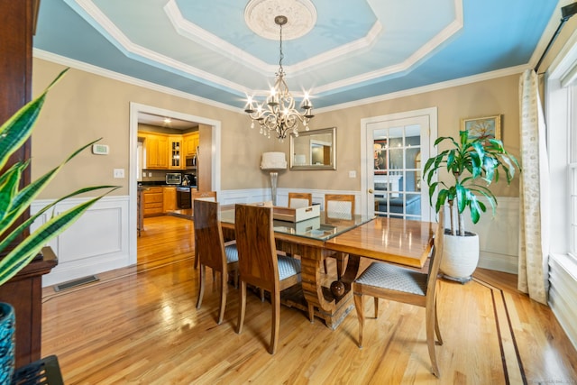 24 Scott Rd, Oxford, CT 06478 - dining room featuring a raised ceiling, a chandelier, light wood finished floors, wainscoting, and plenty of natural light