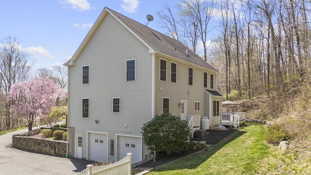 view of property exterior with a lawn, driveway, and an attached garage