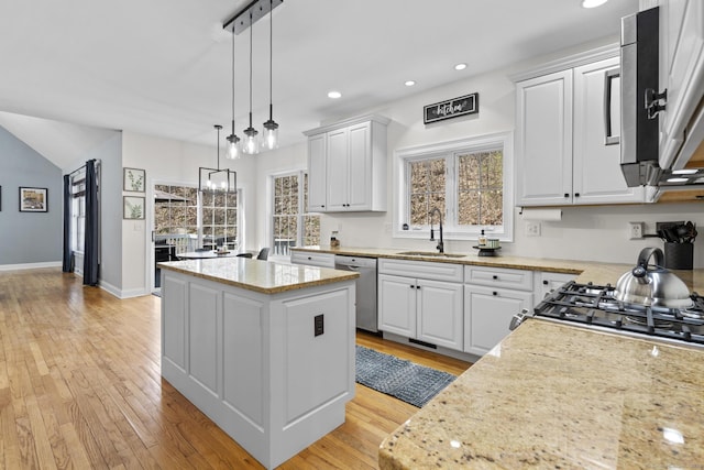 kitchen featuring white cabinets, a center island, dishwasher, and a sink