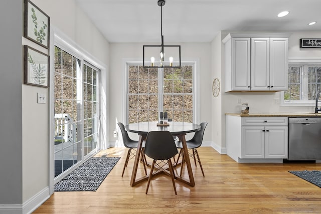 dining room featuring light wood finished floors, recessed lighting, an inviting chandelier, and baseboards