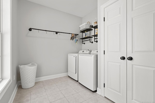 laundry room with light tile patterned flooring, baseboards, laundry area, and washer and clothes dryer