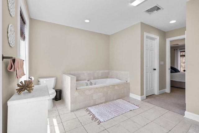 bathroom featuring visible vents, baseboards, toilet, a garden tub, and tile patterned flooring