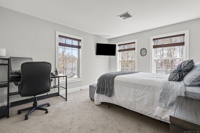 carpeted bedroom featuring baseboards, visible vents, and multiple windows
