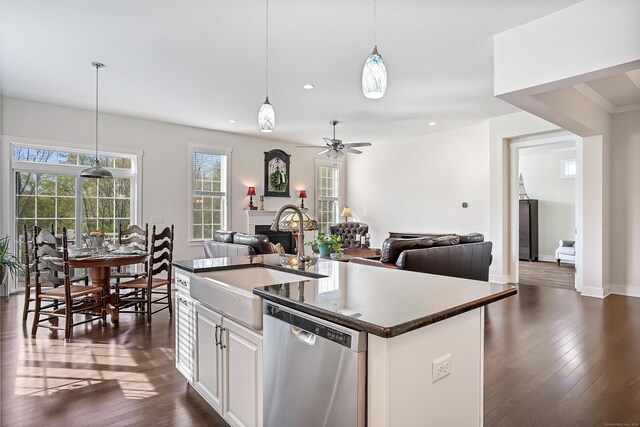 kitchen featuring a sink, dark wood finished floors, open floor plan, decorative light fixtures, and stainless steel dishwasher