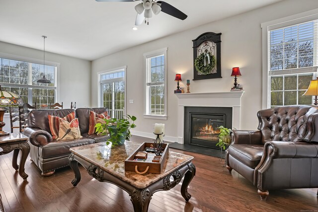 living area with recessed lighting, a glass covered fireplace, ceiling fan, and dark wood-style floors