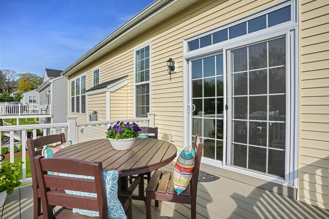 view of wooden balcony featuring a deck and outdoor dining space