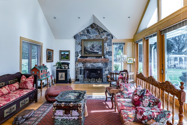 living room with high vaulted ceiling, wood finished floors, and a fireplace