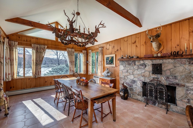 dining area featuring a fireplace, wood walls, a baseboard radiator, beamed ceiling, and a chandelier