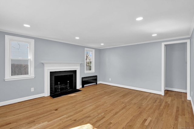unfurnished living room featuring a fireplace with flush hearth, baseboards, recessed lighting, light wood finished floors, and ornamental molding