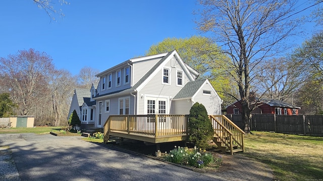 35 Meadow Rd, Clinton, CT 06413 - view of front of property with fence, a front lawn, a shed, a deck, and an outbuilding