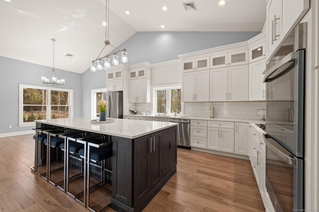kitchen with white cabinets, appliances with stainless steel finishes, and visible vents