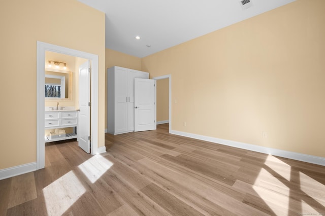 unfurnished bedroom featuring baseboards, light wood-type flooring, and visible vents