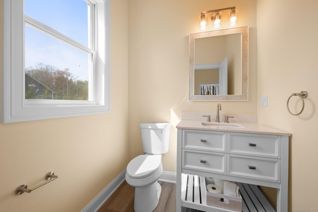 bathroom with baseboards, vanity, and toilet