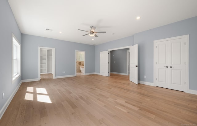 unfurnished bedroom with baseboards, light wood-style flooring, and a closet