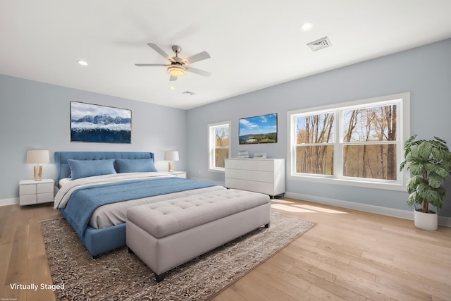 bedroom with baseboards, recessed lighting, wood finished floors, and visible vents
