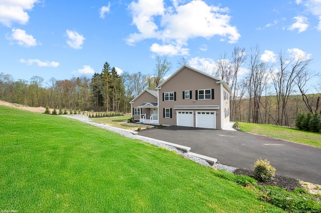 view of front of home with an attached garage, a porch, a front lawn, and aphalt driveway