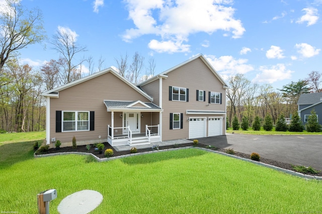 traditional home featuring a porch, an attached garage, a front lawn, and aphalt driveway