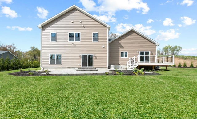 back of property featuring a patio, a wooden deck, and a yard
