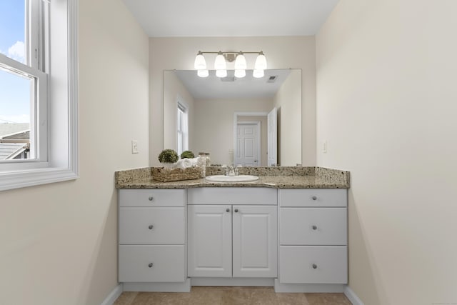 bathroom featuring vanity, baseboards, and visible vents