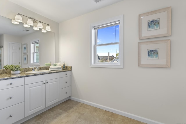 bathroom with baseboards, visible vents, plenty of natural light, and vanity