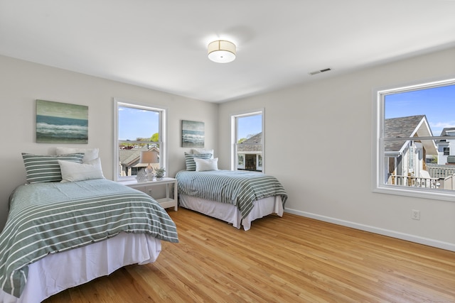 bedroom with baseboards, visible vents, and light wood-style flooring