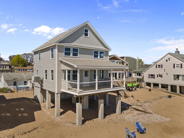 rear view of house with a deck and a shingled roof