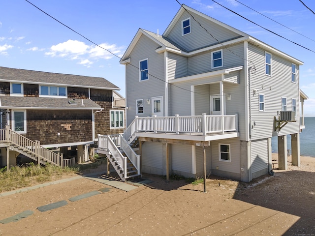 rear view of property featuring cooling unit and stairway