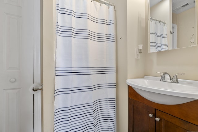 full bath featuring visible vents, a shower with shower curtain, and vanity