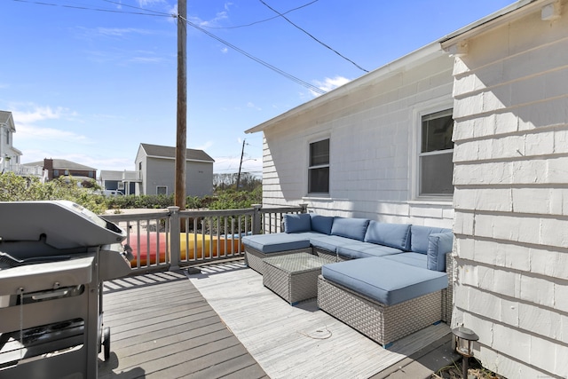 wooden terrace with an outdoor living space and area for grilling