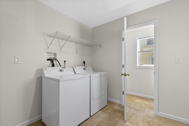 laundry area with washing machine and clothes dryer, baseboards, and laundry area