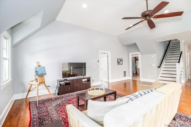 living room featuring stairway, wood finished floors, ceiling fan, and lofted ceiling
