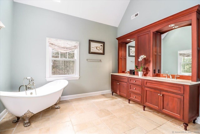 bathroom featuring a freestanding tub, visible vents, a healthy amount of sunlight, and double vanity